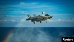 美国海军陆战队一架F-35B战机在南中国海举行的一次飞行行动中正准备在美利坚号两栖攻击舰的甲板上降落。(2020年4月18日)