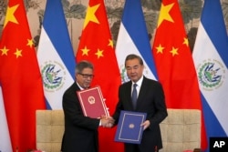 萨尔瓦多外长卡斯塔内达(左)和中国外长王毅在北钓鱼台国宾馆举行的建交仪式上手持建交协定书。(2018年8月21日)。