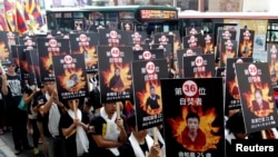 活动人士手举自焚藏人的相片在台北举行支持藏人的游行集会(2013年3月10日)