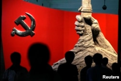 资料照:北京军事博物馆展示的中共党旗与一只握枪的手的雕塑