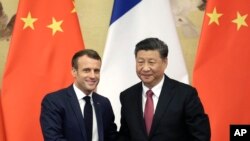 资料照:2019年11月6日,中国国家主席习近平和法国总统马克龙在人民大会堂举行联合记者会后握手。
