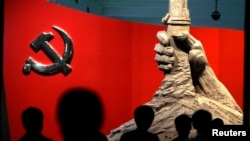 资料照:北京军事博物馆展示的中共党旗与一只握枪的手的雕塑。