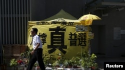 一名保安走过香港政府外民主派抗议者搭建的要求真普选的帐篷 (2016年6月16日)