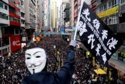 资料照:香港民众打着“光复香港、时代革命”的旗帜参与反政府示威(路透社2019年12月8日)
