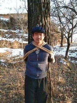 张盼成在甘肃老家村庄把自己绑在树上拍照(华涌推特照片)
