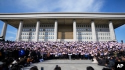 韩国最大在野党共同民主党成员在国会前集会要求总统尹锡悦下台。(美联社:2024年12月4日)