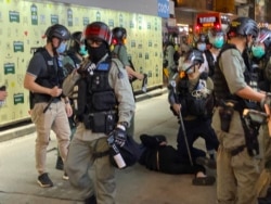 防暴警察制服一名身穿黑衫、黑裤的女子,将她拘捕 (美国之音/汤惠芸)