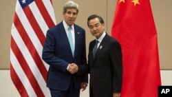 2014年8月9日在第47届东盟外长会议期间美国国务卿约翰·克里(左)和中国外交部部长王毅握手(资料照片)