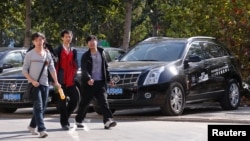 三名青年走过北京一家凯迪拉克汽车销售点。(资料照片)