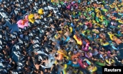 人们在中国辽宁省抚顺市的一个游泳馆里玩水避暑。(2017年7月31日)