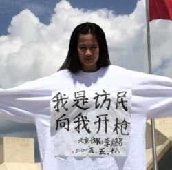 资料照:强拆抗争者李焕君身穿写有“我是访民 向我开枪”的上衣保卫家园。(2015年5月18日)
