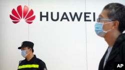 资料照片:一名保安站在中国华为公司在北京国际信息通信展的摊位附近。(2021年9月18日)