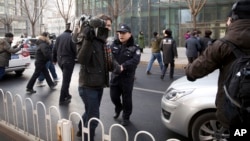 中国政府加大对外国记者的压制。图为2014年1月26日,警察阻止在北京的外国记者采访受审的法律维权人士许志永的辩护律师张庆方。