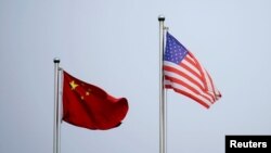资料照片:美中两国国旗在中国上海的一家公司大楼外飘扬。(2021 年4月14 日)