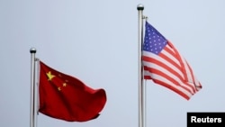 资料照:美中两国国旗在中国上海的一家公司大楼外飘扬。(2021年4月14日)