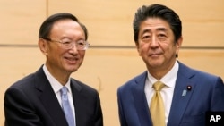 日本首相安倍晋三在东京会见到访的中共中央政治局委员、国务委员杨洁篪。(2020年2月28日)