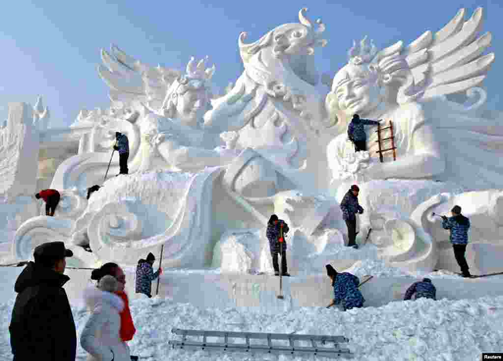 哈尔滨国际冰雪节的雪雕,艺术家和工人正在雕刻(2015年12月22日)