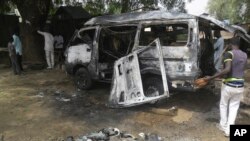 尼日利亚城市波蒂斯库姆发生公交车爆炸后,人们检查这辆汽车