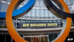 西藏活动人士在位于瑞士洛桑的国际奥委会总部大门处拉起抵制北京冬奥会的横幅。(2021年12月11日)