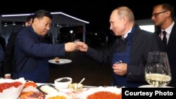 在俄罗斯符拉迪沃斯托克举行的东方经济论坛期间,中国国家主席习近平(左)和俄罗斯总统弗拉基米尔·普京(Vladimir Putin)一边品尝食物,一边敬酒。(2018年9月11日)