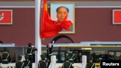 在天安门的毛泽东像前面,武警升起国旗(2013年11月11日)。