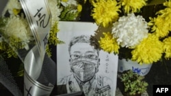 资料照:中国湖北省武汉市中心医院李文亮医生的遗像和供奉的鲜花