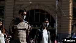 2020年1月29日,在澳大利亚维多利亚州墨尔本确诊了冠状病毒病例后,弗林德斯街车站旁的行人戴着口罩行走。(路透社资料照)