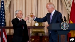 资料照片:2015年7月7日,时任美国副总统乔·拜登(右)与越南共产党总书记阮富仲在华盛顿国务院举行的欢迎午餐会上,共同举杯。(美联社照片)