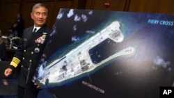 美国海军上将哈里斯走过一张照片,照片显示中国在永暑礁上施工(2015年9月17日)