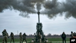 资料照片:2023年1月9日,乌克兰士兵在乌克兰赫尔松地区用美国提供的M777榴弹炮向俄罗斯阵地开火。(美联社照片)