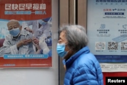 资料照:北京街头张贴鼓励老年人接种新冠疫苗的宣传画。(2022年3月30日)
