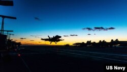 资料照片:在日本海,一架F/A-18F超级大黄蜂战斗机降落在美国海军里根号航空母舰的甲板上。(2022年10月5日)