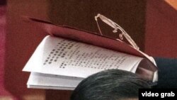 视频截图显示,习近平叫来的工作人员手里拿着那份不许胡锦涛在中共20大会场翻阅的人事名单。