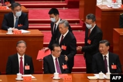 2022年10月22日,在北京人民大会堂举行的中共二十大闭幕式上,习近平看着前中共总书记胡锦涛被警卫扶着离席时拍了一下中国总理李克强的臂膀。
