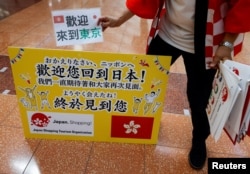 日本一家旅游公司的员工在羽田机场欢迎一个香港旅游团。(2022年6月26日)