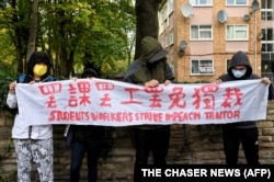 示威者在中国驻曼彻斯特领事馆外手持北京四通桥悬挂反习标语的横幅举行抗议。中国驻曼彻斯特领事馆工作人员随后出来把示威者扯进领事馆内进行殴打。(2022年10月16日)