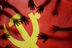 中国江苏连云港的一所小学校的学生在上中共党史课时把手放在中共党旗上。(2020年6月28日)