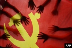 中国江苏连云港的一所小学校的学生在上中共党史课时把手放在中共党旗上。(2020年6月28日)