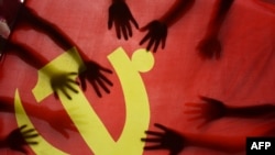 中国江苏连云港的一所小学校的学生在上中共党史课时把手放在中共党旗上。(2020年6月28日)