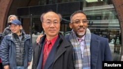 被控非法充当中国政府代理人的波士顿男子梁利堂(Litang Liang,音译)2025年2月10日在被判无罪后和其辩护律师合影。