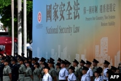 资料照:香港警察站在宣传香港国安法的宣传牌前。(2020年7月1日)