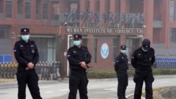 当世卫组织新冠病毒源头调查组视察武汉的中国科学院病毒研究所期间,中国保安人员在研究所外站岗。 (2021年2月3日)