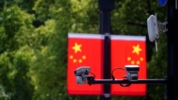上海一家商场悬挂的中国国旗和国旗前的监控摄像头。(2021年5月5日)