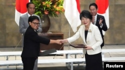2023年12月16日,日本外相上川洋子和印度尼西亚外长蕾特诺在日本东京首相官邸举行的文件交换仪式上握手。(路透社)