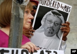 在华盛顿的示威者手持沙特阿拉伯记者卡舒吉(Jamal Khashoggi)的照片(2018年10月10日))