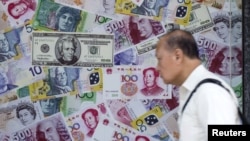 在香港的外汇商店,一名男子走过一个宣传中国人民币(RMB)和其他外国货币兑换服务的橱窗(2015年8月13日)。