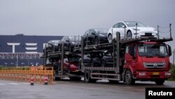 一辆大卡车运出特斯拉上海工厂出产的电动车。(2021年5月13日)