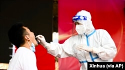 在云南省瑞丽市,一名医务人员在进行核酸检测。(2021年7月5日)