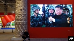 资料照:北京一个展览馆里播放中国领导人习近平手握一杆枪的视频。(2017年10月23日)