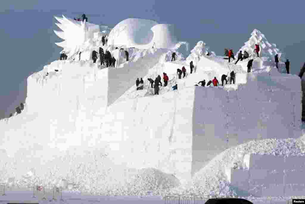 哈尔滨的一座正在雕刻的大型雪雕。一年一度的哈尔滨国际冰雪节即将开幕,准备工作正在进行。(2017年12月6日)